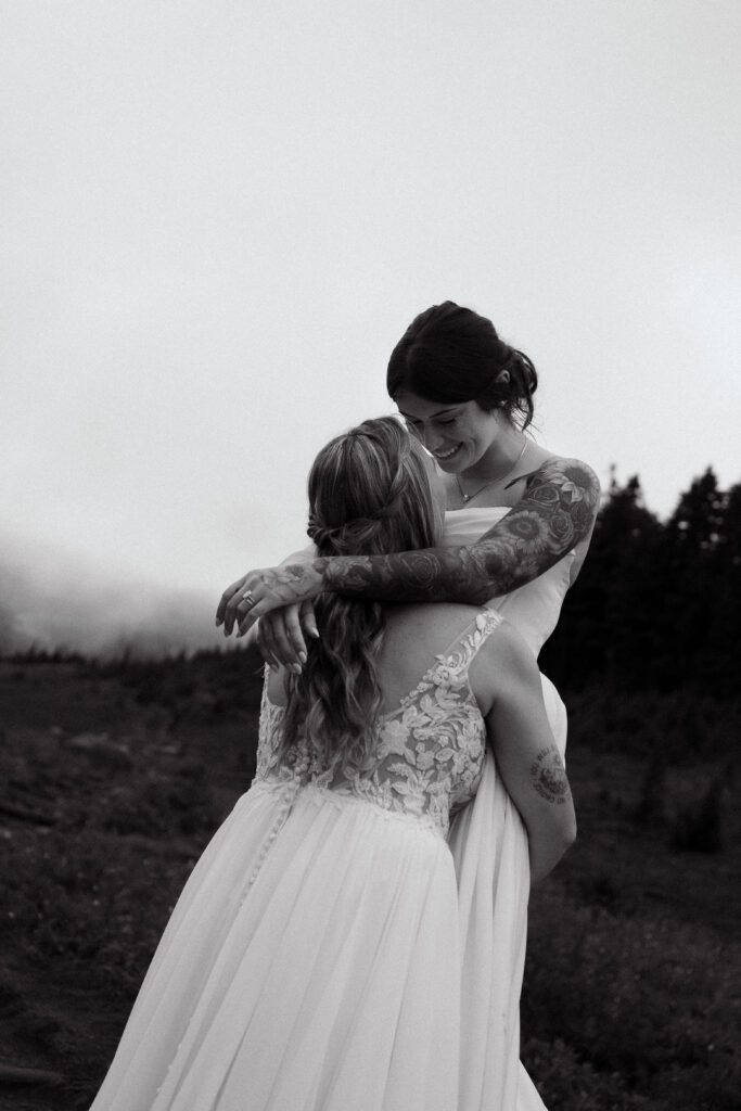 wife lifting her wife up in the air in mt rainier national park during their washington elopement