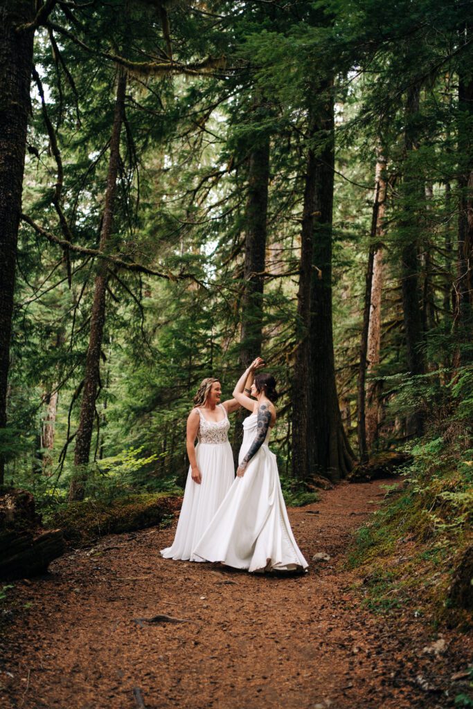 bride twirling her wife in the forest during their mt rainier during their washington elopement