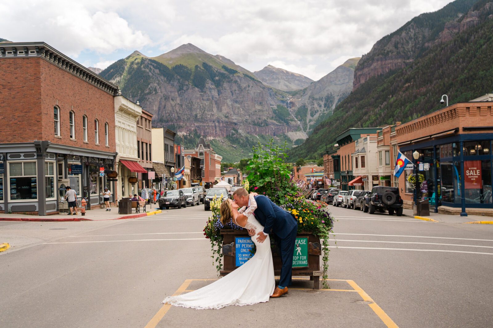 groom kissing bride and leaning her back into a dip in the middle of Telluride during their Telluride elopement