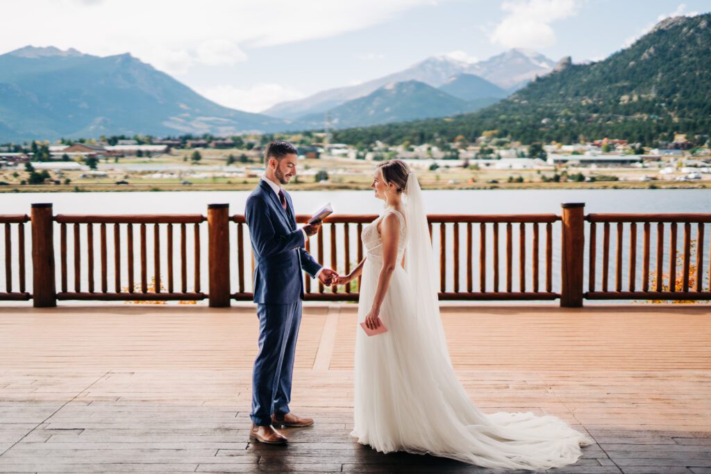 Groom reading his vows to bride on Lake Estes during their Rocky Mountain National Park Elopement