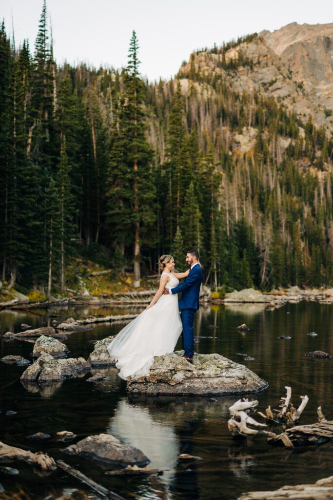 Oliver and Hannah standing on a rock at Dream Lake during their Rocky Mountain National Park Elopement