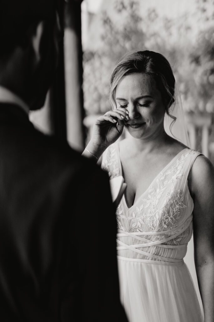 bride wiping away a tear as the groom reads his vows during their rocky mountain national park elopement