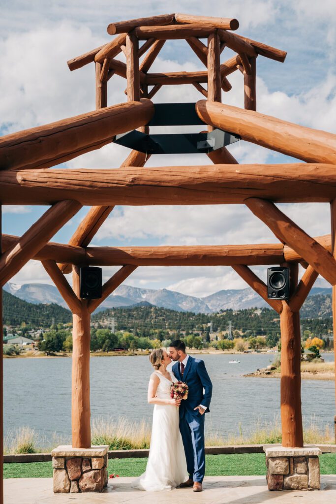 bride and groom kissing under the gazebo at Lake Estes during their rocky mountain national park elopement