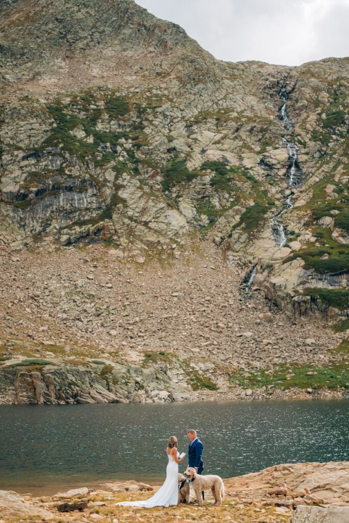 Bride, groom and their two dogs standing by Hope Lake during their Telluride elopement