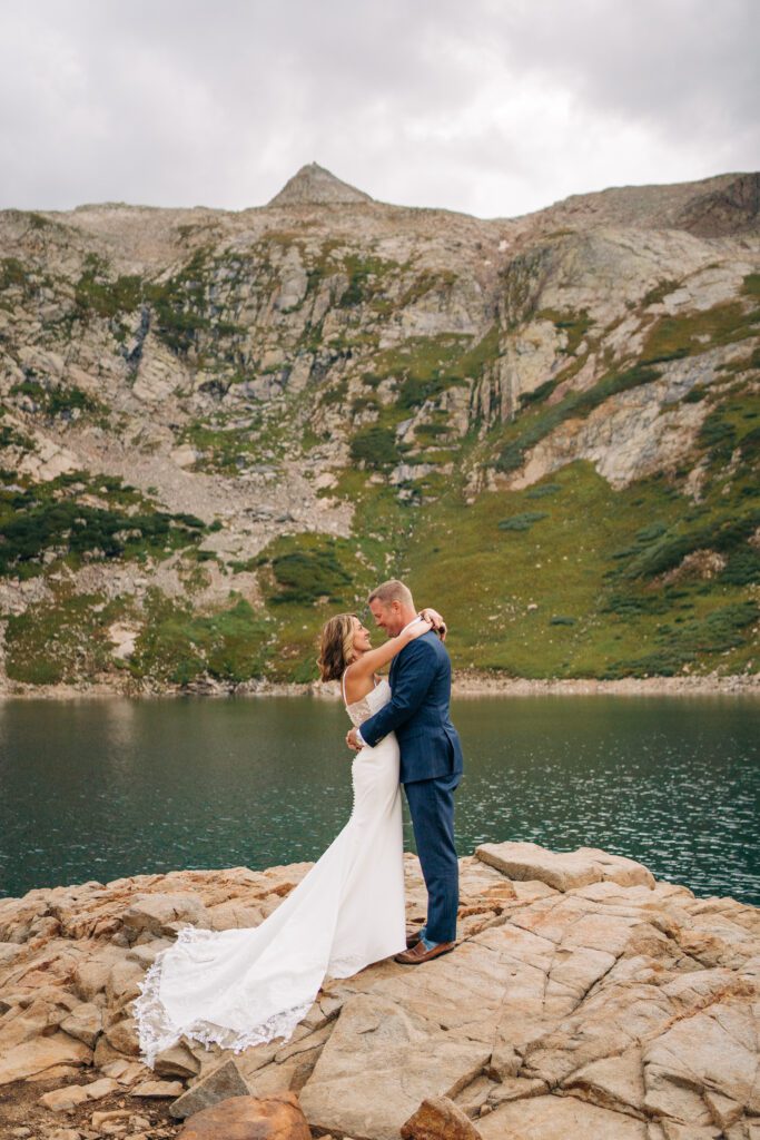 Bride and groom hugging while standing on top of a rock at Hope Lake during their Telluride Elopement