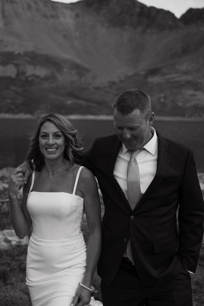 Groom wrapping arm around brides shoulder and walking together during their Telluride elopement