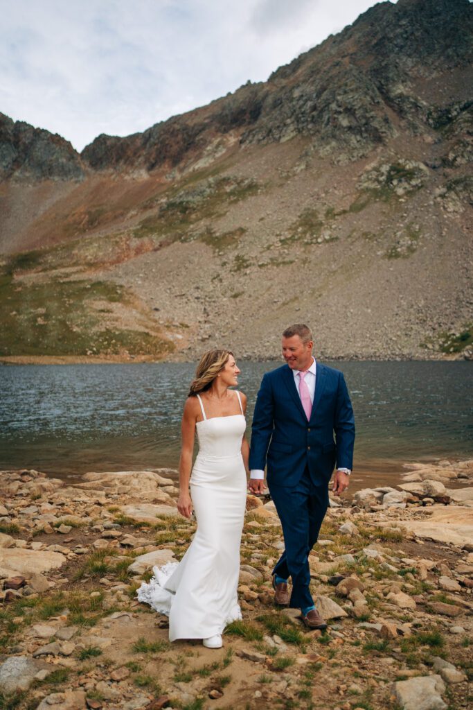 bride and groom walking on the alpine lakeshore during their Telluride elopement